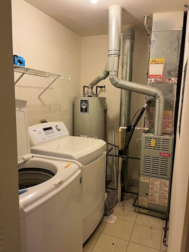 laundry room featuring water heater, laundry area, heating unit, and washer and dryer