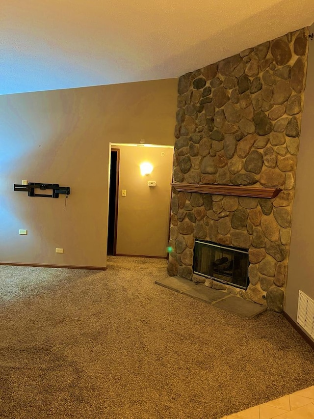 unfurnished living room with visible vents, a fireplace, a textured ceiling, and carpet flooring