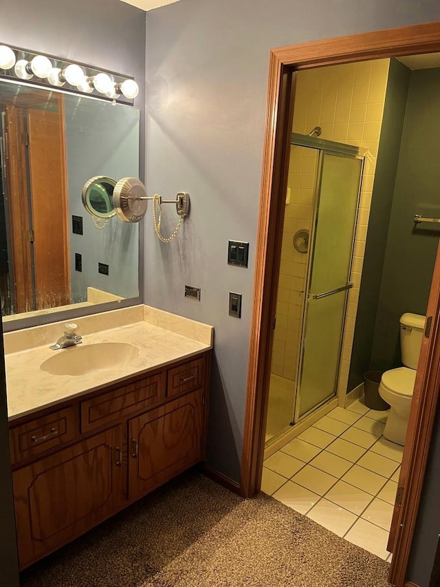 bathroom with vanity, a shower stall, toilet, and tile patterned floors