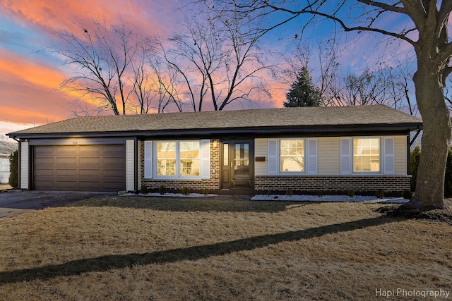 view of front of house with a garage, a lawn, driveway, and entry steps