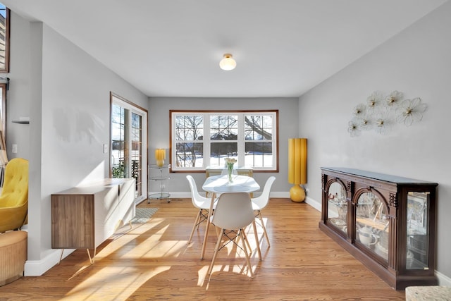 dining space with light wood-style floors and baseboards