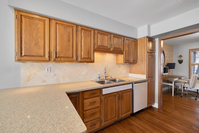 kitchen featuring brown cabinets, backsplash, dark wood-type flooring, white dishwasher, and a sink