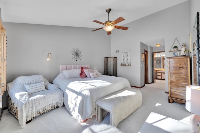 bedroom with connected bathroom, light carpet, a ceiling fan, baseboards, and vaulted ceiling