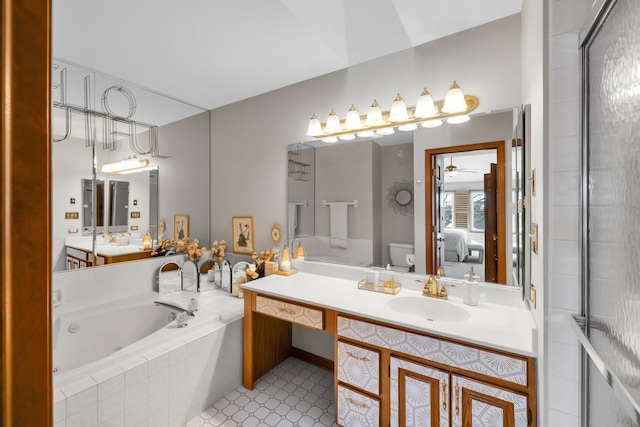 ensuite bathroom featuring toilet, ensuite bath, ceiling fan, a jetted tub, and vanity