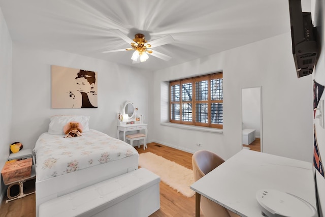 bedroom featuring ceiling fan, baseboards, and wood finished floors