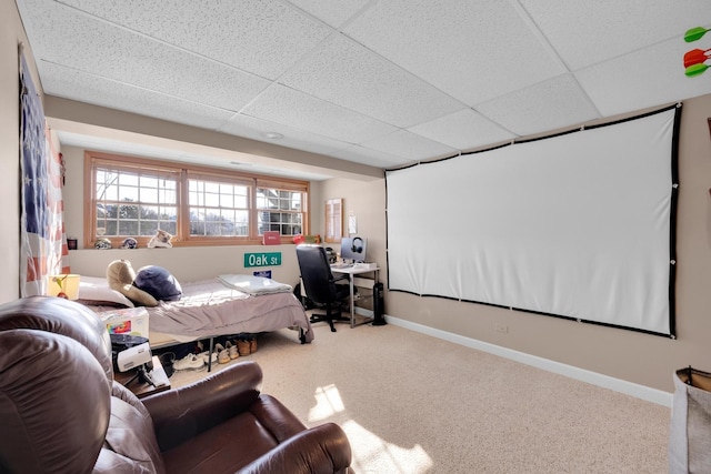 carpeted bedroom with a paneled ceiling and baseboards