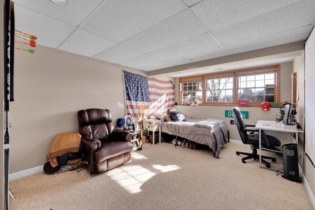 carpeted bedroom with a paneled ceiling and baseboards