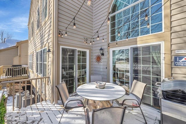 wooden deck with cooling unit, area for grilling, and outdoor dining space