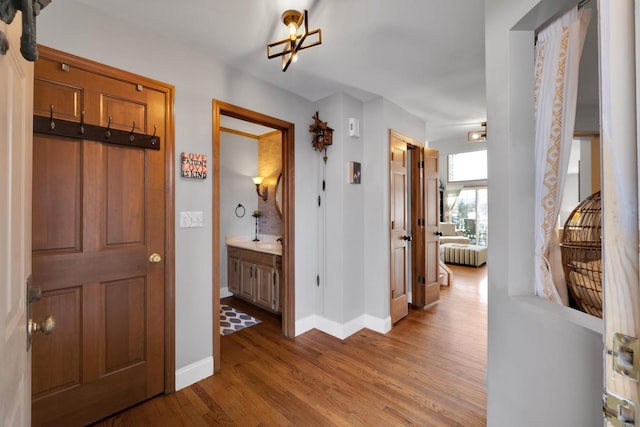 hall with baseboards and wood finished floors