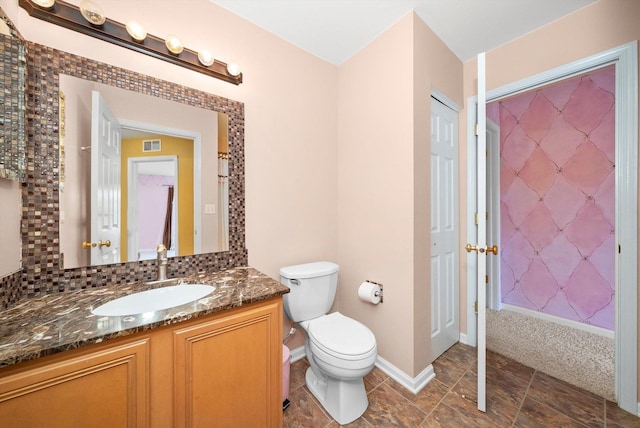 bathroom featuring visible vents, baseboards, toilet, vanity, and backsplash