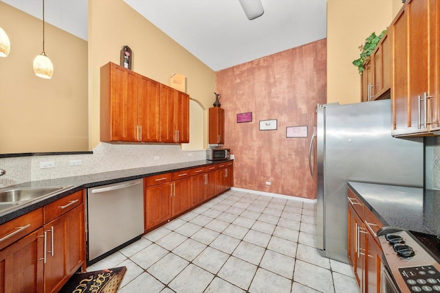 kitchen featuring appliances with stainless steel finishes, dark countertops, a sink, and tasteful backsplash