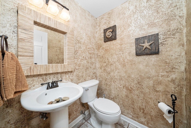 bathroom featuring baseboards and toilet