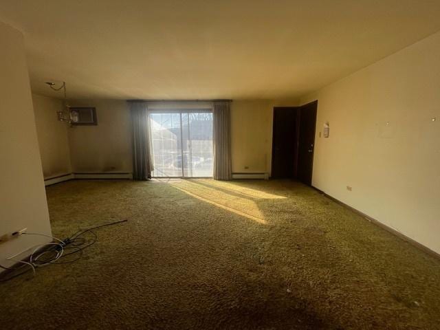 spare room with a baseboard heating unit, a wall unit AC, baseboard heating, and carpet