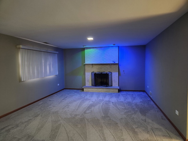 unfurnished living room featuring carpet floors, a brick fireplace, visible vents, and baseboards