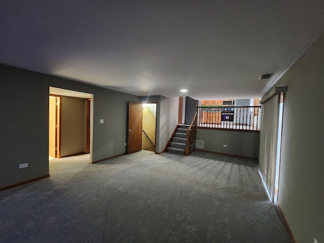 below grade area featuring baseboards, stairs, visible vents, and carpet flooring