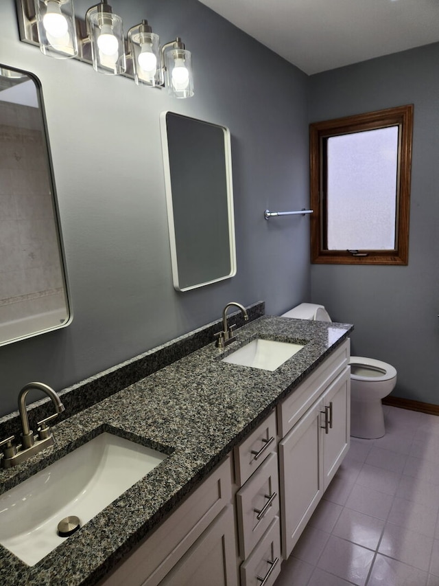 full bath with toilet, double vanity, a sink, and tile patterned floors