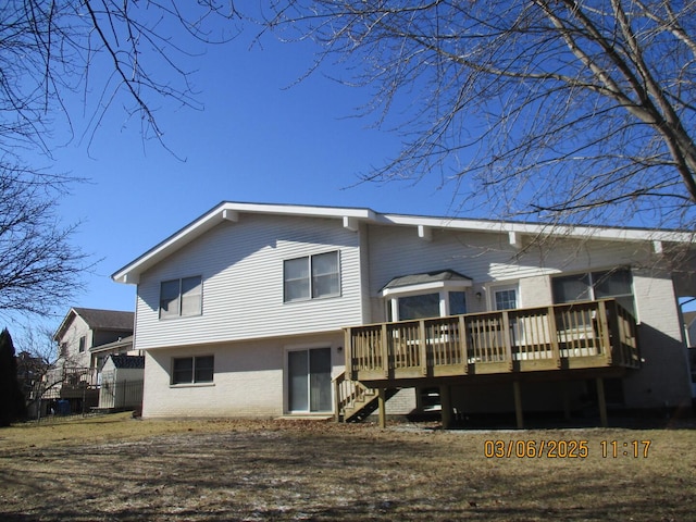 rear view of property with a deck, brick siding, and stairway