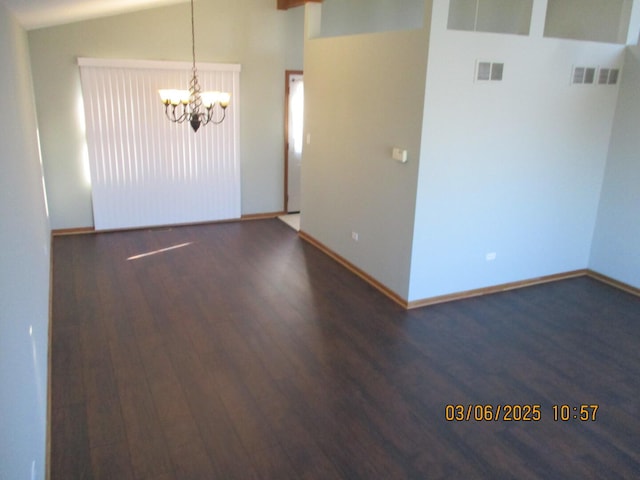 unfurnished room with a chandelier, lofted ceiling, visible vents, and wood finished floors