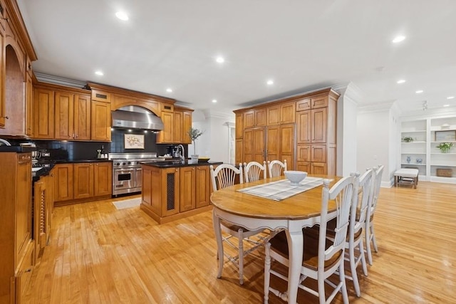 kitchen featuring light wood finished floors, double oven range, wall chimney exhaust hood, and crown molding