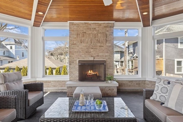 sunroom featuring beamed ceiling, wooden ceiling, and an outdoor brick fireplace