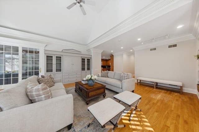 living area featuring visible vents, light wood-style floors, and crown molding