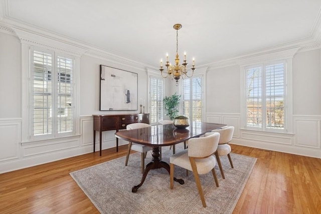 dining room with a wealth of natural light, light wood finished floors, and an inviting chandelier