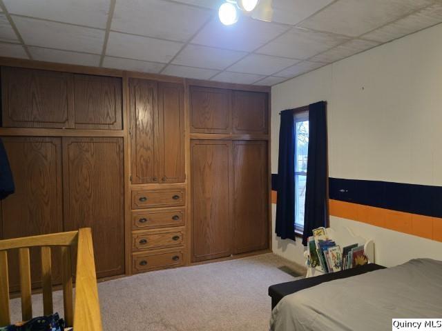 carpeted bedroom featuring a paneled ceiling