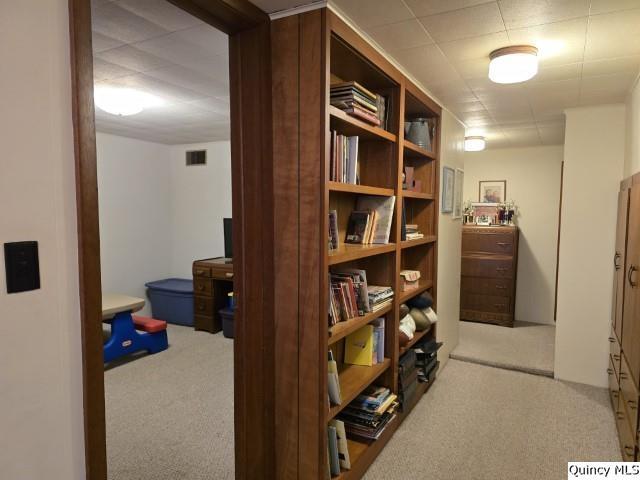 hallway featuring carpet floors and visible vents