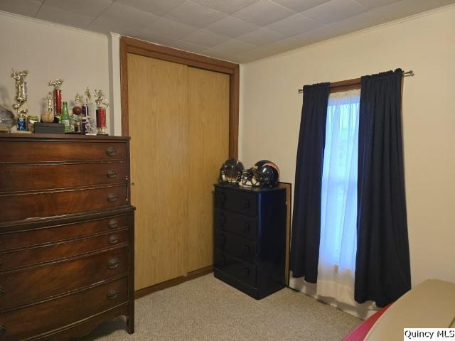 bedroom featuring a closet and light colored carpet