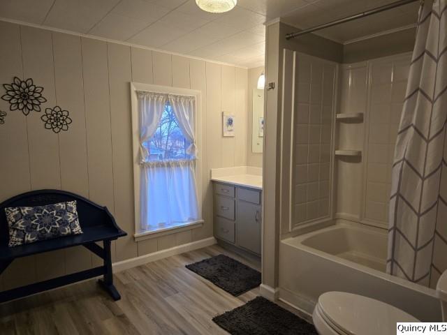 bathroom featuring toilet, a wealth of natural light, shower / bath combo, and wood finished floors