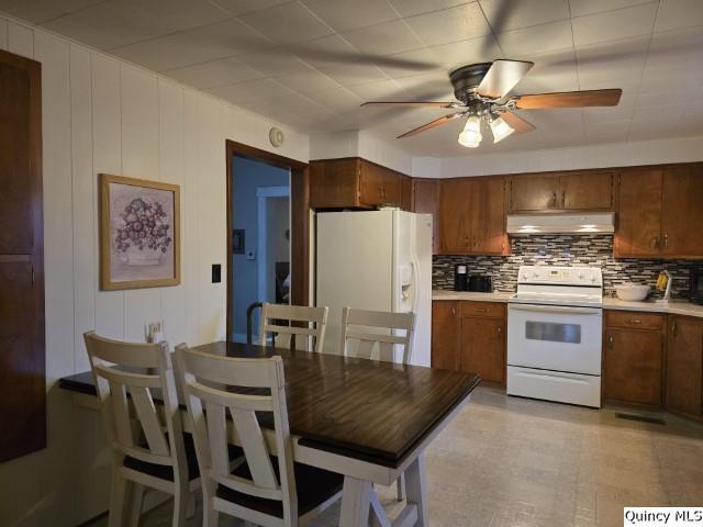 kitchen with a ceiling fan, white appliances, light countertops, and under cabinet range hood