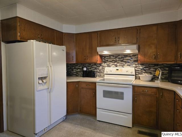 kitchen featuring white appliances, under cabinet range hood, visible vents, and light countertops