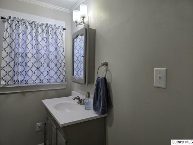 bathroom with ornamental molding and vanity