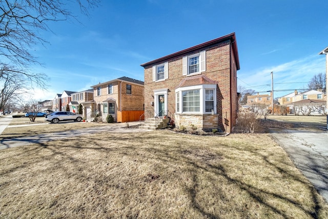 view of front facade featuring a front lawn, stone siding, brick siding, and a residential view