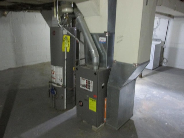 utility room featuring water heater, washer / clothes dryer, and heating unit