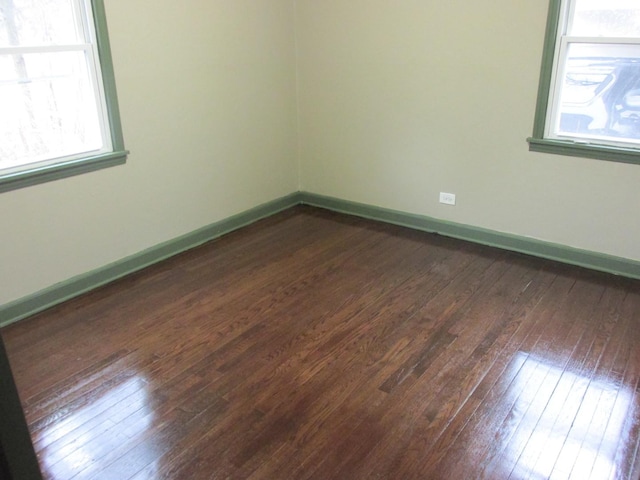 spare room with dark wood finished floors and baseboards