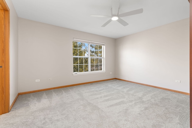 unfurnished room with a ceiling fan, light colored carpet, and baseboards