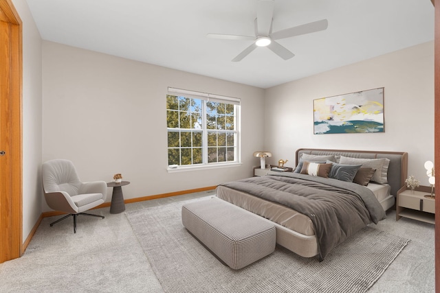 carpeted bedroom with ceiling fan and baseboards