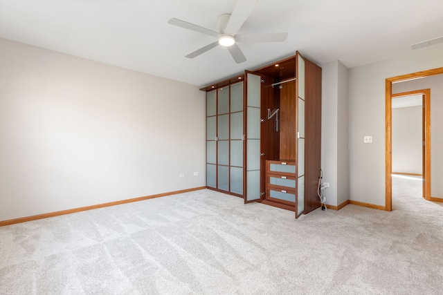 carpeted empty room featuring a ceiling fan, visible vents, and baseboards