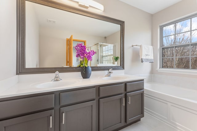 full bath with double vanity, a sink, a bath, and a shower stall