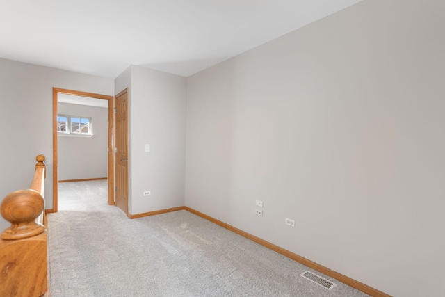 unfurnished room featuring light carpet, visible vents, and baseboards