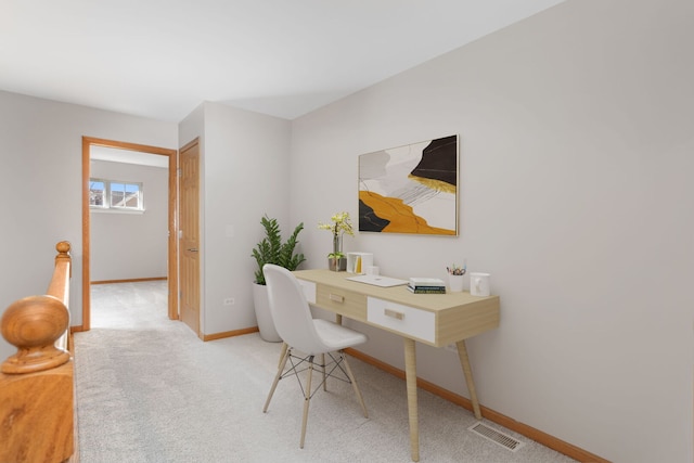 office space featuring light colored carpet, visible vents, and baseboards