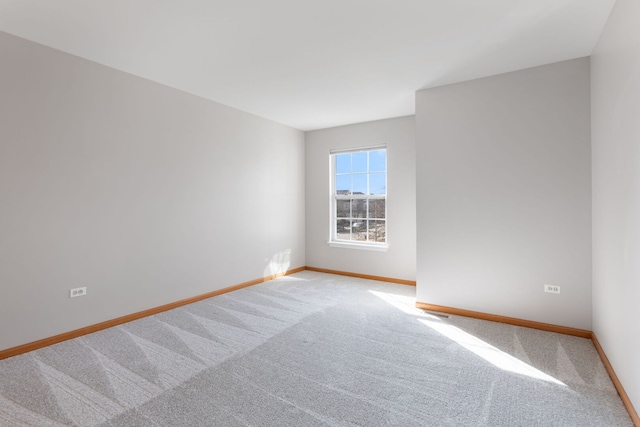 carpeted spare room with baseboards