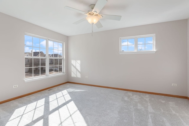 spare room featuring ceiling fan, carpet, visible vents, and baseboards