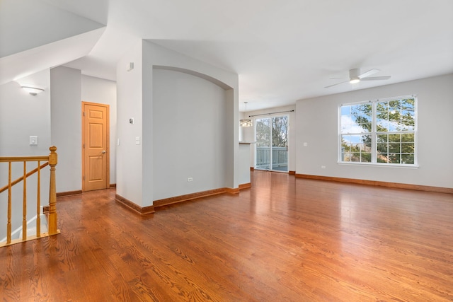 empty room with ceiling fan, baseboards, and wood finished floors