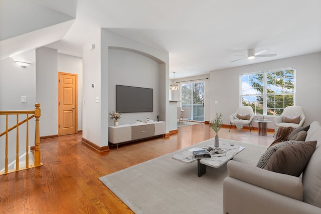 living area featuring a ceiling fan, wood finished floors, a wealth of natural light, and baseboards