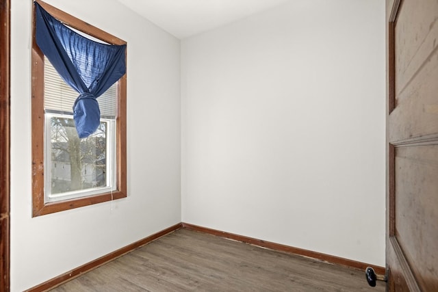 empty room with baseboards and wood finished floors