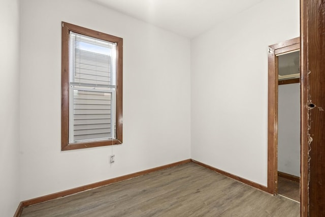 empty room featuring wood finished floors and baseboards