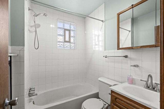 full bath with toilet, tile walls, shower / washtub combination, and vanity