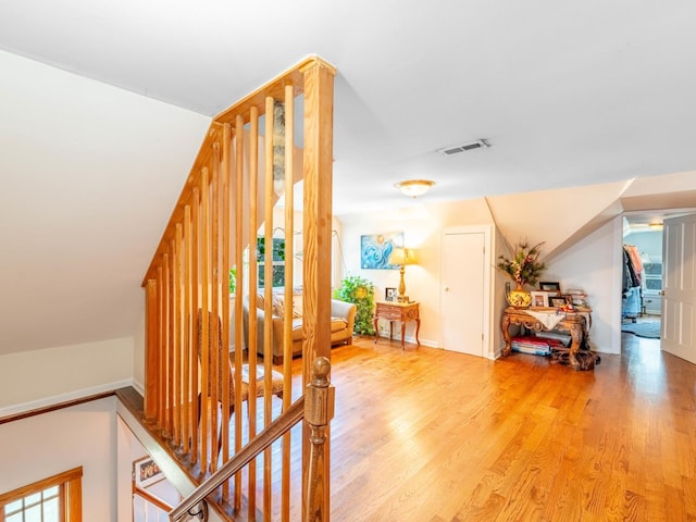 stairs with wood finished floors and visible vents